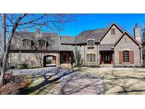 Beautiful brick home featuring a circular driveway and a porte-cochere leading to a garage at 3820 N Berkeley Lake Nw Rd, Berkeley Lake, GA 30096