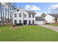 Charming white two-story home with a well-manicured lawn and black trim accents at 310 Mulberry Manor Ct, Johns Creek, GA 30005