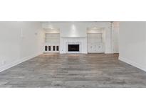 Bright living room featuring a fireplace, built-in shelving, and wood-look flooring at 3636 Peachtree Ne Rd # 405, Atlanta, GA 30319