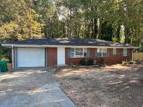 Charming red brick ranch home with attached garage and well-maintained front yard landscaping at 687 N Hairston Rd, Stone Mountain, GA 30083