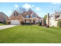 Charming two-story brick home with manicured lawn and inviting front porch at 1102 White Cloud Rdg, Snellville, GA 30078