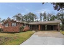 Charming brick home with a covered carport and a well-maintained front yard in a suburban setting at 2630 Colonial Dr, College Park, GA 30337