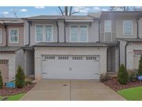 Charming townhome featuring a two-car garage, neutral siding, and manicured landscaping at 2136 Garden Pl, Atlanta, GA 30316