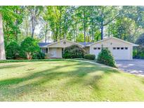 Charming ranch-style home featuring a spacious front yard with mature trees and a two-car garage at 130 Bonnie Ln, Sandy Springs, GA 30328