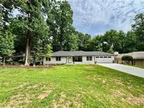 Ranch-style home with a well-manicured lawn, mature trees and a long driveway at 1759 Wilmont Ne Dr, Atlanta, GA 30329