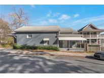 Quaint gray home featuring a covered front porch, mature shrubs, and a well-maintained facade on a sunny day at 235 Dodd Sw Ave, Atlanta, GA 30315