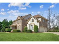 Charming two-story home with a well-manicured lawn, lush landscaping, and an attached two-car garage at 3915 Northridge Dr, Cumming, GA 30040