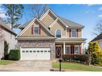 Charming two-story home with stone accents, red shutters, attached two-car garage, and well-maintained lawn at 513 Mirramont Pl, Woodstock, GA 30189