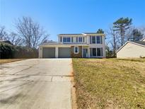 Split-level home featuring two-car garage, neutral colors, and large windows at 901 Chapman Cir, Stone Mountain, GA 30088