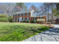 Charming two-story brick home with a well-manicured lawn, dark shutters, and a welcoming entrance at 1121 Valley Ridge Se Ct, Marietta, GA 30067