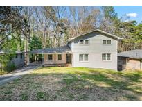 Inviting two-story home with covered porch and carport, nestled on a lush, treed lot, offering both charm and convenience at 2717 Hedgewood Nw Dr, Atlanta, GA 30311