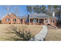 Charming single-Gathering home with a brick facade, covered porch, and well-maintained landscaping at 4741 Covenant Way, Powder Springs, GA 30127
