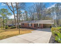 Charming brick home with a long driveway and mature trees, offering a serene and inviting atmosphere at 4941 Crowe Se Dr, Smyrna, GA 30082