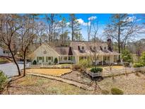 Charming home featuring a landscaped front yard and inviting covered porch, surrounded by mature trees at 103 Eubanks Ct, Woodstock, GA 30188