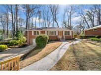 Charming brick home featuring manicured front lawn, inviting walkway, and classic architectural details at 750 Parkway Se Dr, Smyrna, GA 30080