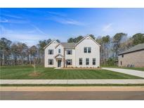 Two-story home featuring a brick facade, gabled roof, and manicured front yard at 200 Haverling Pass, Hampton, GA 30228