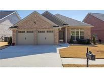 Charming brick home featuring a two-car garage and manicured front lawn with a convenient mailbox at 9204 Malcolm Dr, Covington, GA 30014