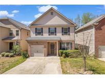 Charming two-story home with a brick facade, gray siding and a well-manicured front lawn at 11961 Lovejoy Crossing Way, Hampton, GA 30228