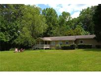 Charming ranch-style home featuring a spacious front yard and inviting covered porch with outdoor seating at 1537 David Lee St, Acworth, GA 30102