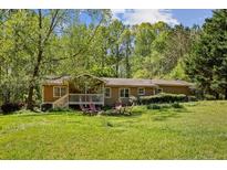 Cozy single-story home with a well-maintained lawn and mature trees at 1537 David Lee St, Acworth, GA 30102
