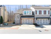 Charming two-story home with a two-car garage and landscaped front yard at 185 Bellehaven Dr, Woodstock, GA 30188