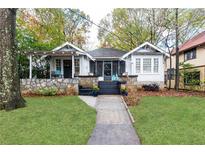 Charming bungalow with a stone foundation, inviting front porch, and lush landscaping at 1252 Mclendon Ne Ave, Atlanta, GA 30307