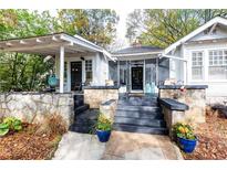 Charming craftsman home featuring a covered porch with stone accents and freshly painted stairs at 1252 Mclendon Ne Ave, Atlanta, GA 30307
