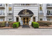 Welcoming condo building entrance at the St James at Buckhead with a black awning and decorative golden door at 3203 Lenox Ne Rd # 1, Atlanta, GA 30324