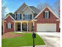 Charming two-story brick home with a well-manicured lawn, mature trees, and inviting front porch at 405 Eaglewood Way, Canton, GA 30115