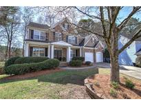 Charming brick home with a well-manicured front yard and covered front porch at 301 Windswept Ct, Powder Springs, GA 30127