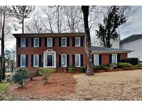 Charming two-story brick home with black shutters and a well-manicured lawn at 4614 Blakedale Cir, Roswell, GA 30075