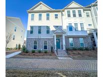 Charming townhome featuring brick accents, neutral siding, and a welcoming front entrance with a teal-colored door at 361 Watson Ave, Woodstock, GA 30189