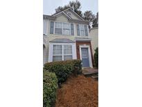 Charming two-story townhome featuring a welcoming front entrance and well-maintained landscaping at 911 Redwood Dr, Norcross, GA 30093