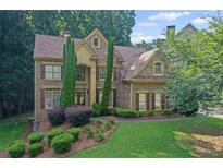 Stunning two-story brick home with lush landscaping and a well-manicured lawn creates lovely curb appeal at 403 Glenhurst Trce, Canton, GA 30115