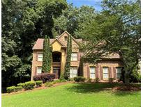 Charming two-story brick home with a well-manicured lawn and mature trees at 403 Glenhurst Trce, Canton, GA 30115