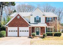 Charming two-story home with a brick front, attached two-car garage and a well-manicured lawn at 2225 Saint Thomas Way, Suwanee, GA 30024
