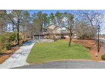 Charming two-story home with a well-manicured lawn and a long driveway leading to an attached two-car garage at 230 N Talbot Ct, Roswell, GA 30076