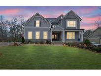 Charming two-story home with a well-manicured lawn and a welcoming front porch at dusk at 430 Parkbrook Way, Canton, GA 30114