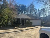 Charming single-story home featuring a well-manicured lawn and attached two-car garage at 5860 Elm Tree Dr, Buford, GA 30518