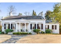 Charming white home featuring a classic facade with black shutters and a well-maintained front lawn at 2 W Muscogee Nw Ave, Atlanta, GA 30305
