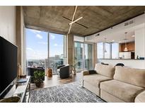 Bright living room with floor-to-ceiling windows and open concept layout into the modern kitchen at 855 Peachtree St # 2901, Atlanta, GA 30308