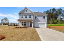 Charming two-story home featuring a covered front porch and attached two car garage at 537 Teversham Dr, Mcdonough, GA 30253