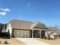 Charming home featuring a two-car garage, stone accents, and manicured landscaping at 1649 Auburn Ridge Way, Dacula, GA 30019