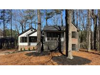 Charming home featuring a partial brick facade, covered porch, and nicely landscaped front yard at 1038 Knotts Pointe Dr, Woodstock, GA 30188