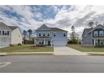 Charming two-story home featuring a manicured lawn, covered porch, and a two-car garage at 238 Arnewood Cir, Mcdonough, GA 30253