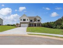 Beautiful two-story home featuring a manicured lawn, a two-car garage, and a brick and siding exterior at 127 Felicity Pike, Locust Grove, GA 30248
