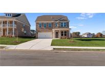 New two-story brick home with a two-car garage, well manicured lawn and a concrete driveway under a blue sky at 237 Chiswick Loop, Stockbridge, GA 30281