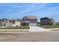 Beautiful new two-story home with a manicured lawn and a two car garage at 132 Dalston Cv, Stockbridge, GA 30281