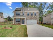 Charming two-story brick home with a well-manicured lawn and a two-car garage at 132 Dalston Cv, Stockbridge, GA 30281
