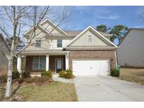 Inviting brick front home features a two-car garage and well-manicured landscaping at 2417 Overlook Ave, Lithonia, GA 30058